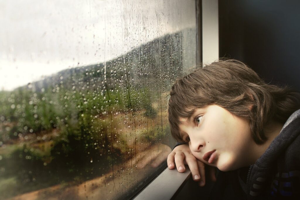 Kind blickt aus Fenster Langeweile Warum ist Schule so langweilig
