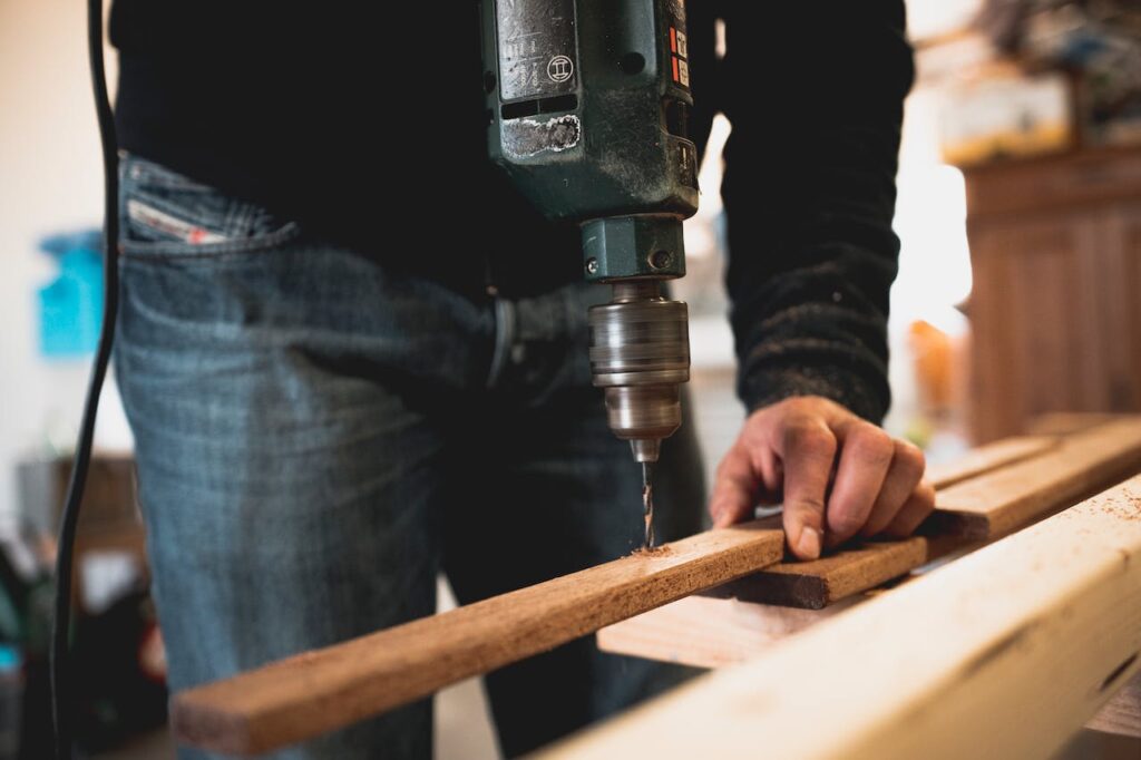 Mann Handwerk Bohrmaschine Holz DIY Projekt Studentenwohnung Terrasse selber bauen